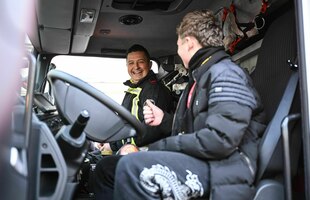 Ein Feuerwehrmann und ein Jugendlicher sitzen in einem Feierwehrauto