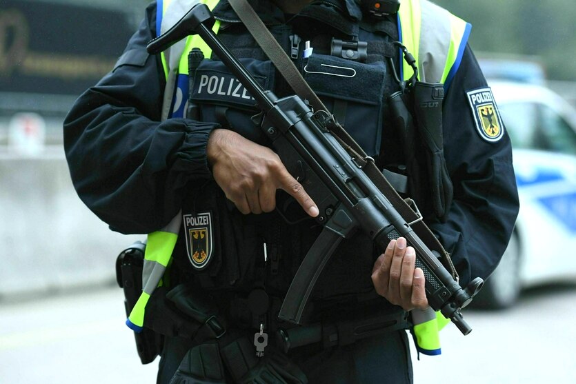 Ein schwerbewaffneter Polizist steht am Grenzübergang zu Österreich