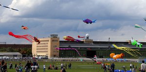 Menschen lassen auf dem Tempelhofer Feld Drachen steigen