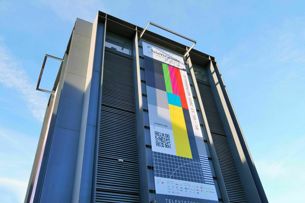 Ein buntes Plakat hängt an einem Hochhaus
