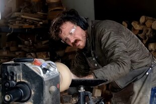 Ein Mann schneidet Holz an einem Werkzeug