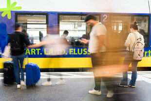 Fahrgäste stehen am Hauptbahnhof Hannover an einem Regionalzug und schauen auf ihr Handy.