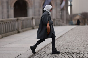 eine Frau trägt einen Balaclava und läuft über die Straße