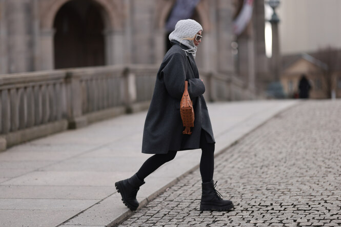 eine Frau trägt einen Balaclava und läuft über die Straße