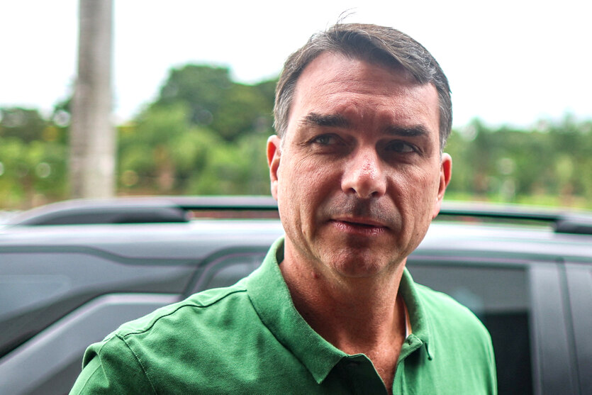 Flávio Bolsonaro steht in einem grünen Poloshirt vor einem Auto