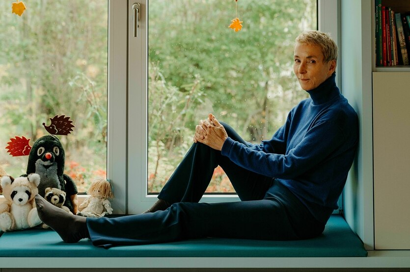 Portrait eine Frau, die auf einer Fensterbank sitzt