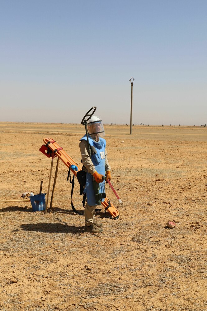 David Francis trägt Schutzkleidung und steht in einer Wüstenlandschaft