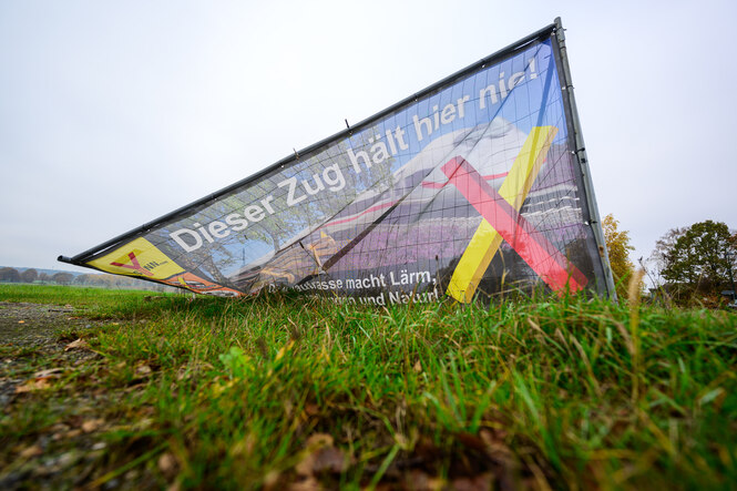 auf einem halb umgefallenen Transparent steht "Dieser Zug hält hier Nie!"