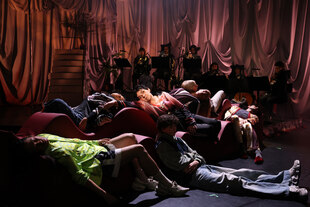 Menschen liegen auf einer Bühne