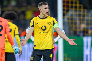 Ein junger Fußballspieler in BVB-Trikot steht auf dem Platz und macht eine Geste des Ärgers