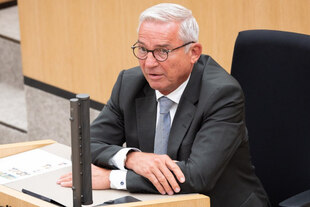 Innenminister Strobl im Zeugenstand, Anzug tragend, graues Haar, Brille.