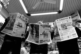 Drei Personen halten jeweils eine Zeitung vor ihr Gesicht: La Stampa, La Repubblica und Il Secolo XIX.
