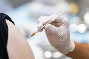 Impfung: Arm mit Hand und Spritze