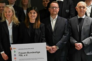 Zwei Frauen und zwei Männer mit einer überdimensional großen Gründungsurkunde