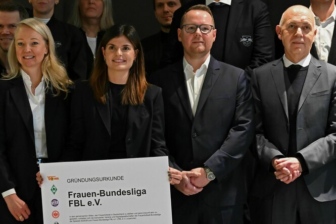 Zwei Frauen und zwei Männer mit einer überdimensional großen Gründungsurkunde