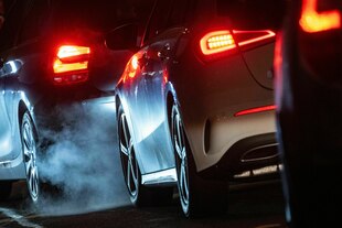 Autoabgase sind hinter einem Kraftfahrzeug im Straßenverkehr zu sehen