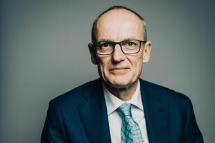 Ein Mann mit Brille lächelt in die kamera