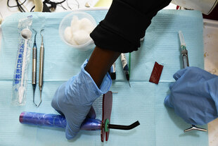 Eine Person arrangiert medizinische Geräte auf einem Tisch.