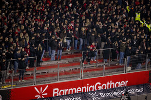 Zuschauertribüne mit unbesetzten Reihen vor dem Zaun