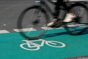 Ein Fahrrad fährt über einen grünen Radstreifen