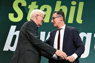 Zwei Männer scherzen miteinander auf einer Bühne