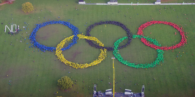 Mehrere hundert Menschen bilden im Stadtpark die Olympischen Ringe nach