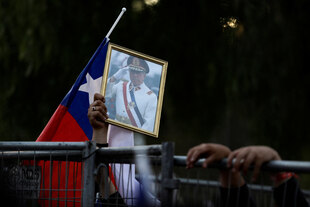 Eine Person hält ein Foto des ehemaligen chilenischen Diktators Präsident Augusto Pinochet Ugarte in der Hand.
