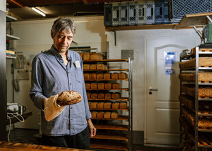 Geschäftsführer Andreas Striegnitz präsentiert ein Brot in der Backstube der Mehlwurm-Bäckerei