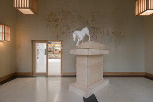 Ein Sockel, von dem ein Pferd steigt, in einer Ausstellung
