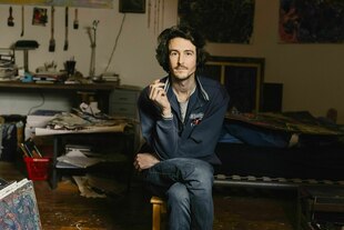 Ein Mann sitzt in seiner Wohnung und raucht