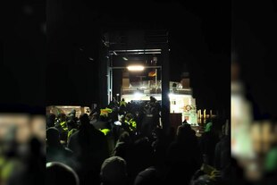 Schummrige Nachtszene, eine Fähre in der Ferne, dunkle Gestalten im Vordergrund, wütende Bauern hindern den damaligen Vizekanzler Robert Habeck (Grüne) in Schlüttsiel in Schleswig-Holstein am Verlassen einer Fähre