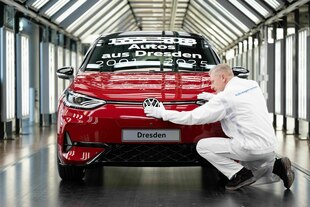 Ein Volkswagen und ein Arbeiter in einer Fabrik.