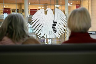 Zwei Frauen, von hinten gesehen, verfolgen von der Besuchertribüne aus die Sitzung des Bundestags