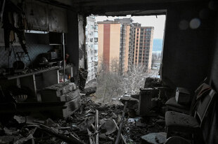 Das Innere der beschädigten Wohnung in einem Wohnhaus, das von einem russischen Drohnenangriff getroffen wurde, mit Blick auf das Nachbarhochhaus, welches unbeschädigt scheint