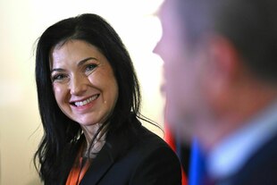 Katherina Reiche grinst über ihre Schulter in die Kamera