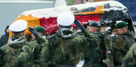 Soldaten tragen bei einer Probe für den Staatsakt für Helmut Schmidt einen mit einer Bundesflagge bedeckten Sarg.