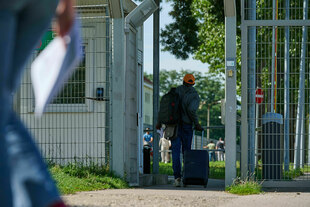 Gefluechteter vor dem Eingangstor der BAMF in Eisenhuettenstadt