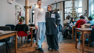 Zwei Frauen stehen in den Räumen des Cafés International