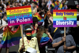 CSD in Berlin, TeilnehmerInnen fordern mit Schildern in Regenbogenfarben Solidarität mit Polen und die heilige Dreifaltigkeit ist Diversität