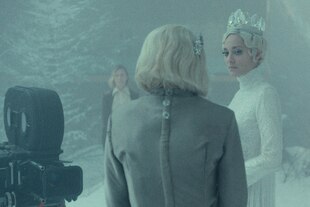 Filmszene - in eis-grünem Farbton gehalten, eine junge Frau mit Krönchen auf dem Kopf und weissem Kleid - eine Frau in einem hellen Kleid steht mit dem Rücken zum Betrachter