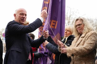 Kai Wegner und Ute Bonde hissen eine Flagge zum Tag gegen Gewalt an Frauen