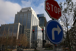 Ein Stop-Schild steht vor einem großen Gebäude