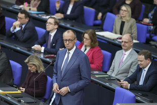 Friedrich Merz steht im Bundestag und beantwortet Fragen