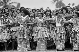 Schwarz-weiß-Aufnahme von Tänzerinnen und Tänzern in traditioneller Kleidung