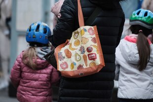 Eine erwachsene Person und zwei Kinder von hinten