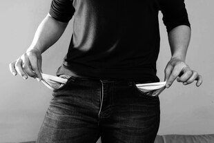 Eine Person zeigt ihre leeren Taschen