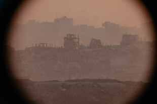 Blick durch ein Fernglas auf Trümmer in Gaza