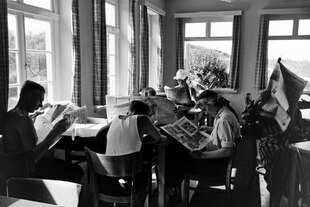 In einem Wartesaal lesen wartende Reisende die aktuelle Tageszeitung