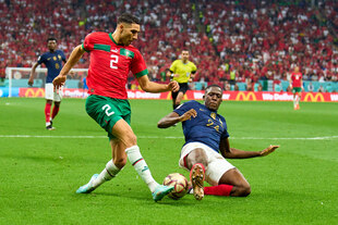 Marokkos Nationalspieler beim Schuss, ein französischer Gegenspieler versucht den Ball noch wegzugrätschen