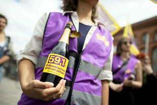 Demonstrant feiert mit einer Flasche Sekt auf einer Kundgebung